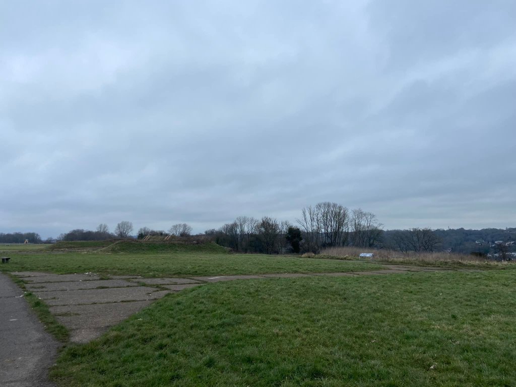 grass with information board and blast pen in the distance